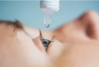 a photo of a boy applying eye drops