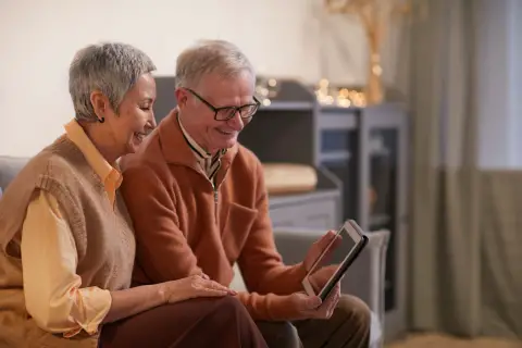 an image of 2 people using one tablet computer