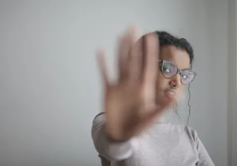 a photo of a female with hand up posing halt