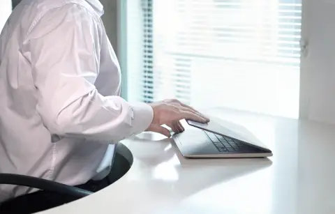an image of a person closing a laptop's screen