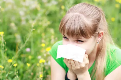 a female sneezing in the field