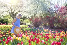 an older woman walking in flower field